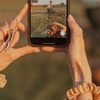 Руки тримають смартфон і знімають вертикальне відео